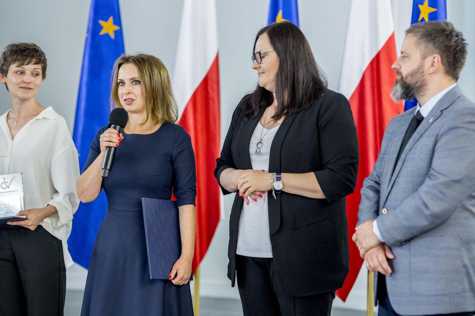 Anna Czekalska dziękuje za wyróżnienie w konkursie obok (w ciemnym żakiecie) stoi wiceminister Inwestycji i Rozwoju Małgorzata Jarosińska-Jedynak