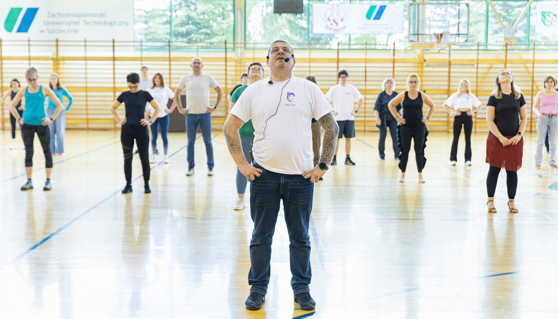 Prorektor na sali gimnastycznej na tle tańczących osób