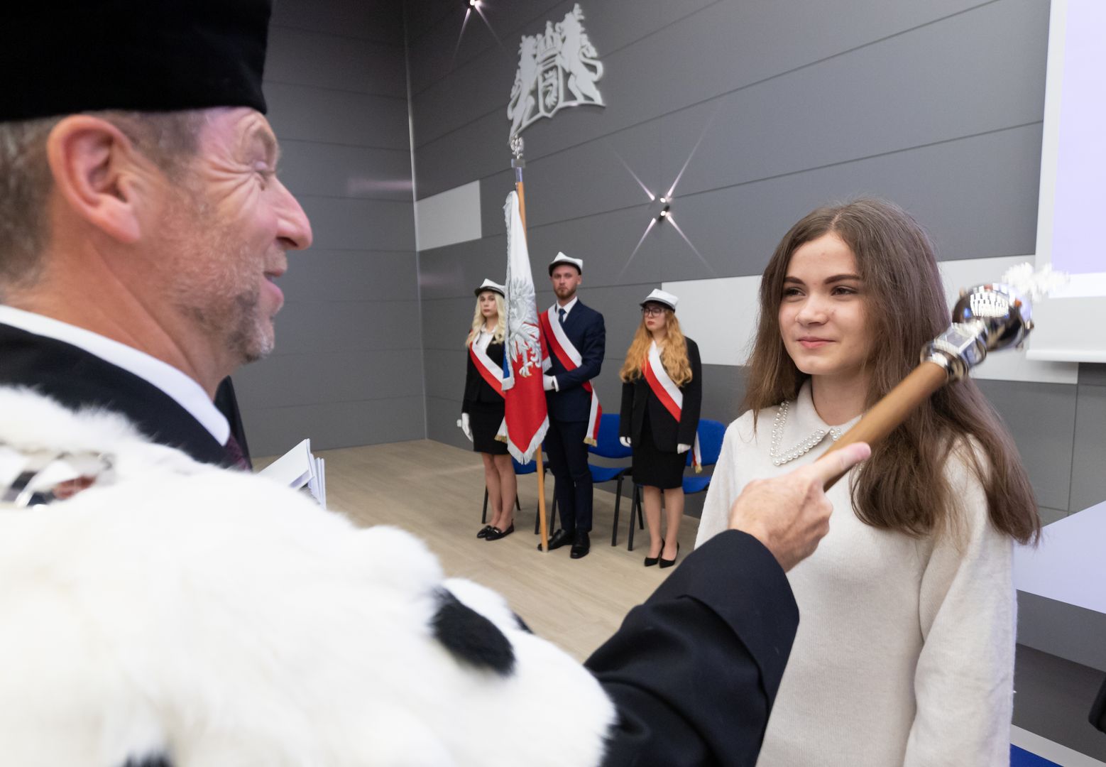 Rektor dotknięciem berła immatrykuluje studentów