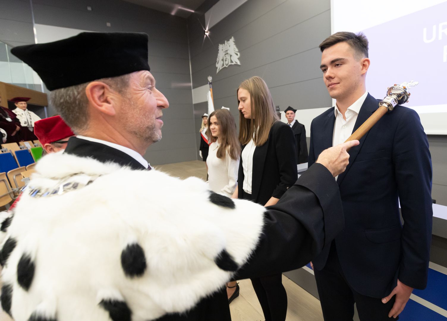 Rektor dotknięciem berła immatrykuluje studentów