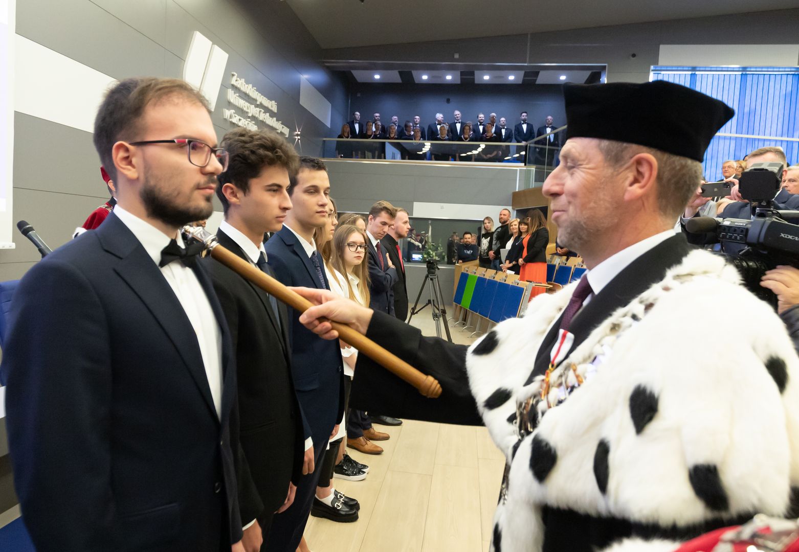 Rektor dotknięciem berła immatrykuluje studentów