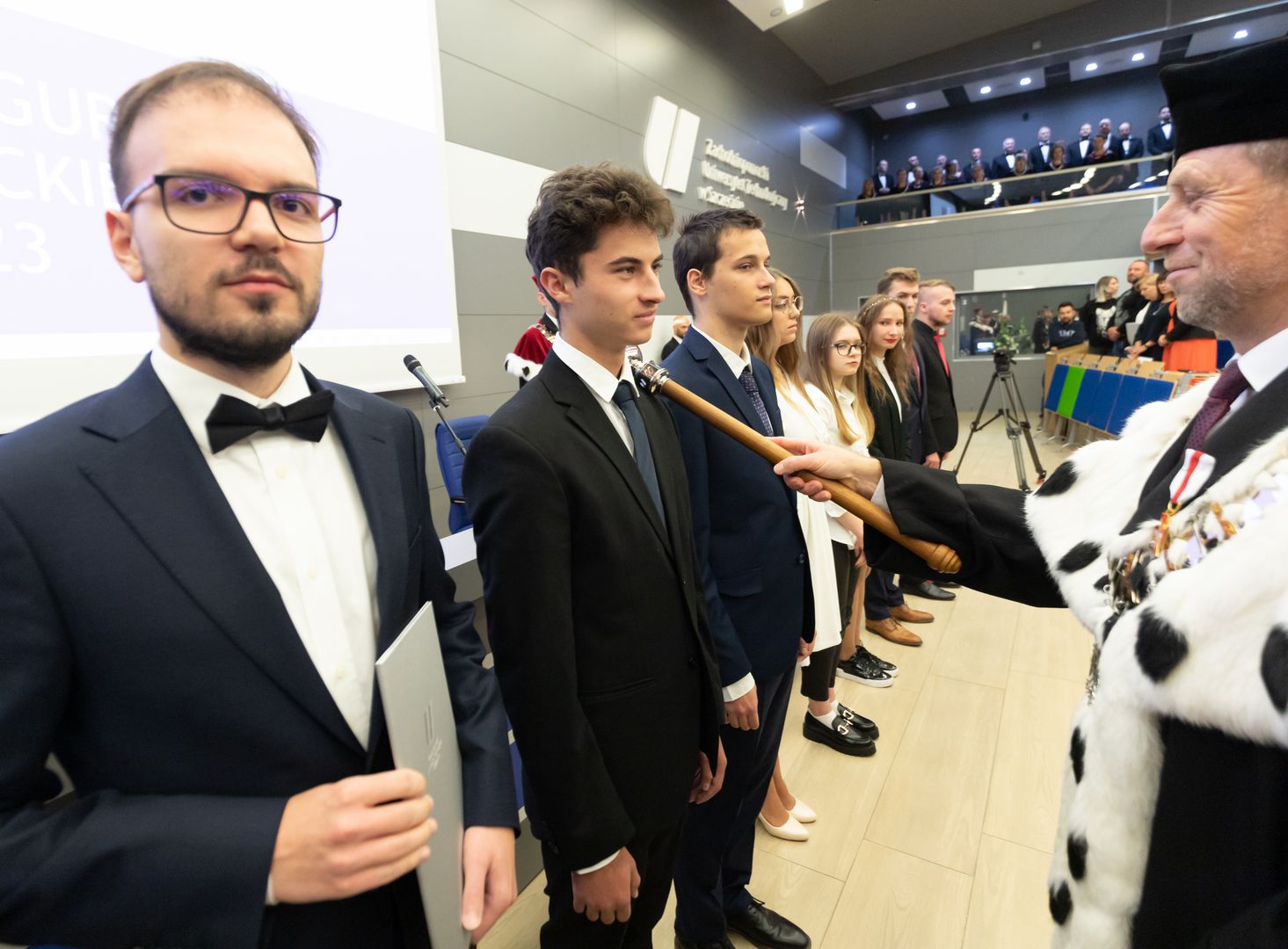 Rektor dotknięciem berła immatrykuluje studentów
