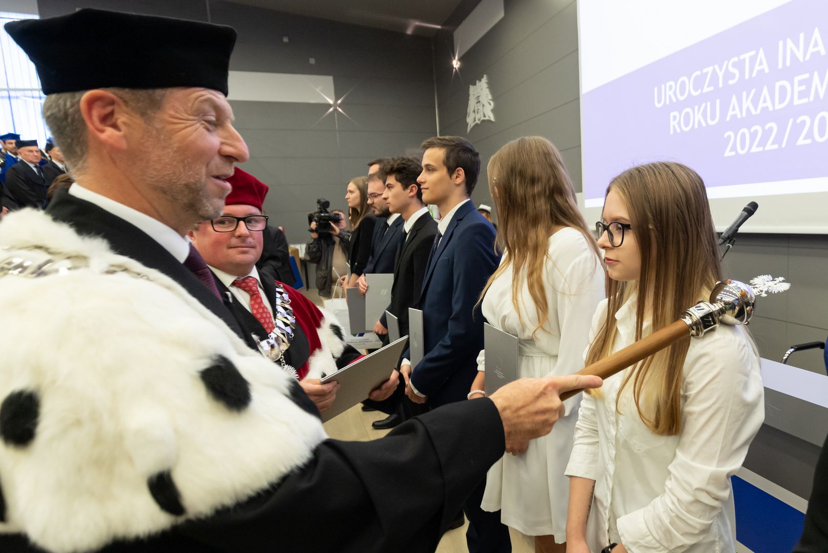 Rektor dotknięciem berła immatrykuluje studentów